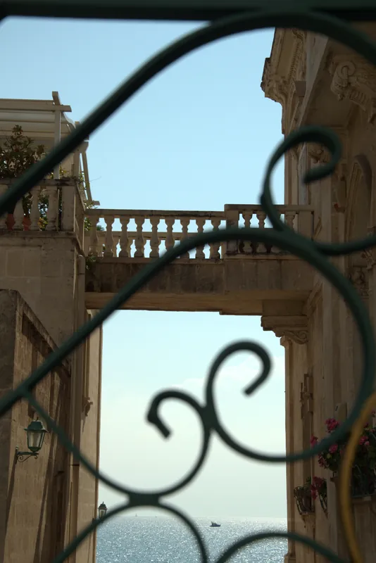 Aperçu d'un palais et de la mer à travers les volutes d'une grille en fer, Tarente