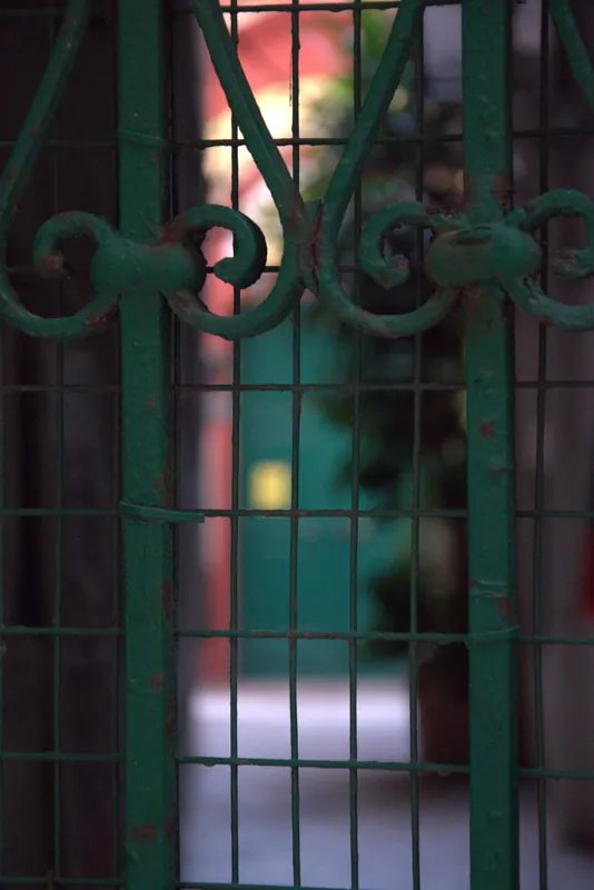 Les volutes d'une grille verte devant une cour, Tarente