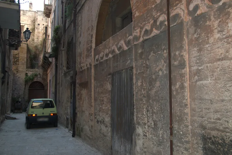 Une petite Fiat phares allumés dans une ruelle de la vieille ville, Tarente (plaque masquée)
