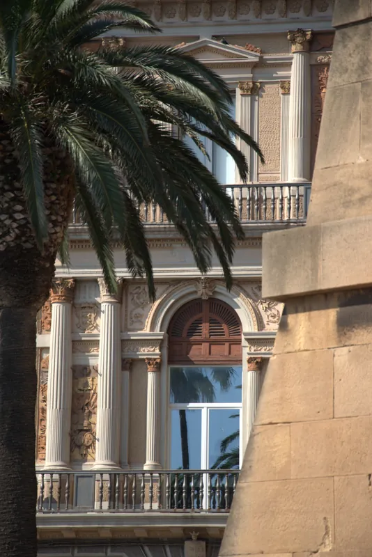 Une fenêtre décorée derrière un palmier, Tarente