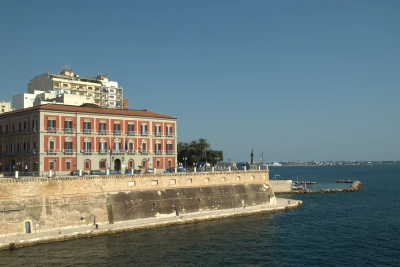 Un palais rouge au-dessus des remparts le long du canal, Tarente