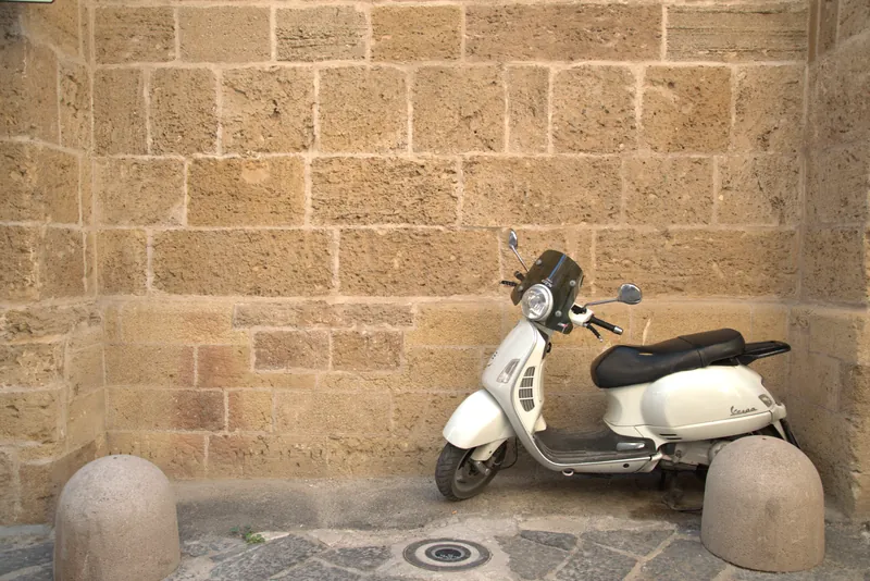 Une Vespa blanche contre le mur de pierre, Tarente
